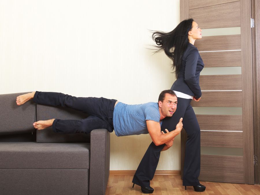 Man desperately clinging to the leg of a woman